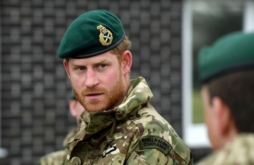 Prince Harry in his military uniform with a green hat.