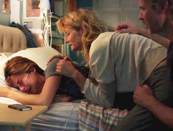 Hazel Grace crying in bed with her parents surrounding and consoling her