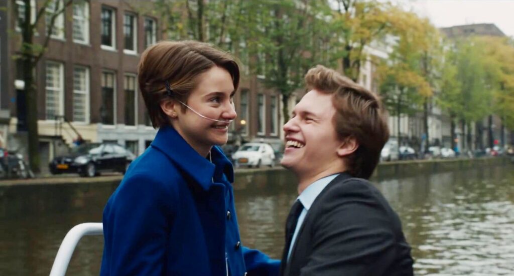 Hazel and Augustus on a boat in Amsterdam smiling and laughing