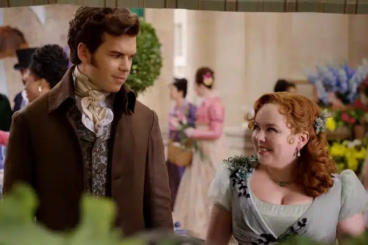 Colin Bridgerton and Penelope Featherington smile at each other.