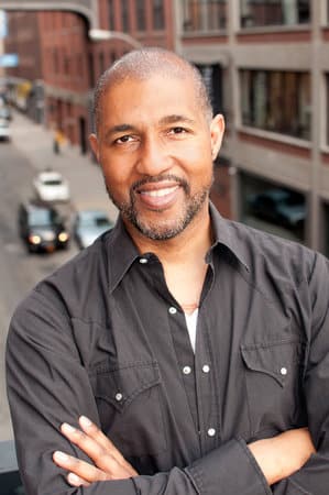 dion-graham-smiling-on-a-bridge-over-a-street