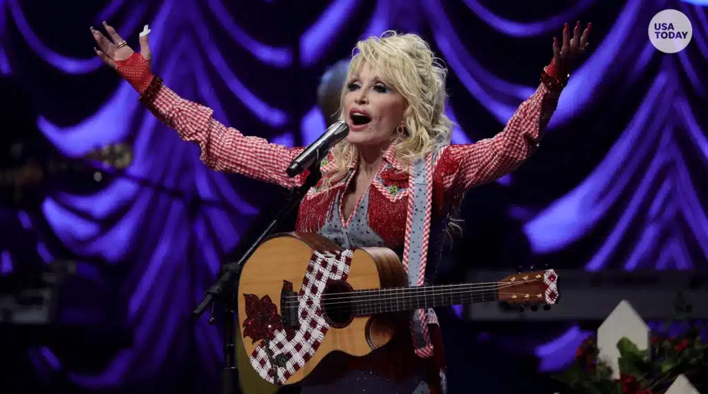 dolly-parton-singing-on-stage-with-a-guitar