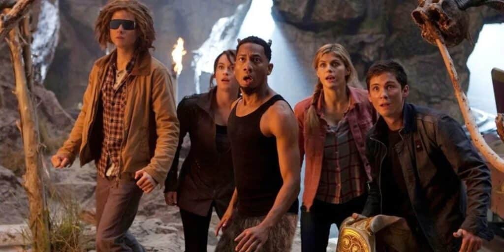 group-of-teens-huddle-together-in-cave-looking-up-grover-friends-percy-jackson