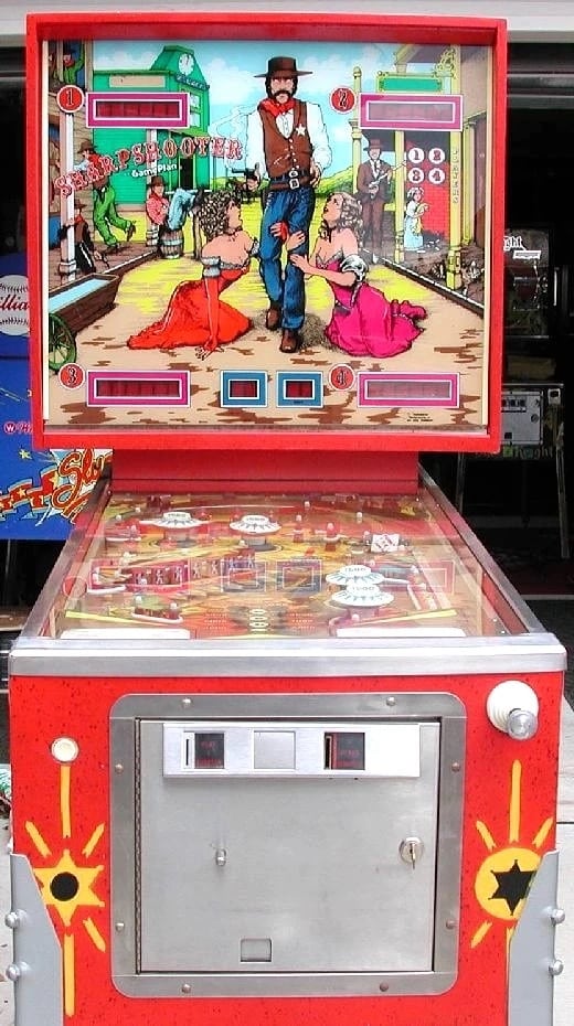 The Sharpshooter- Pinball- machine- man in hat with two woman at his feet