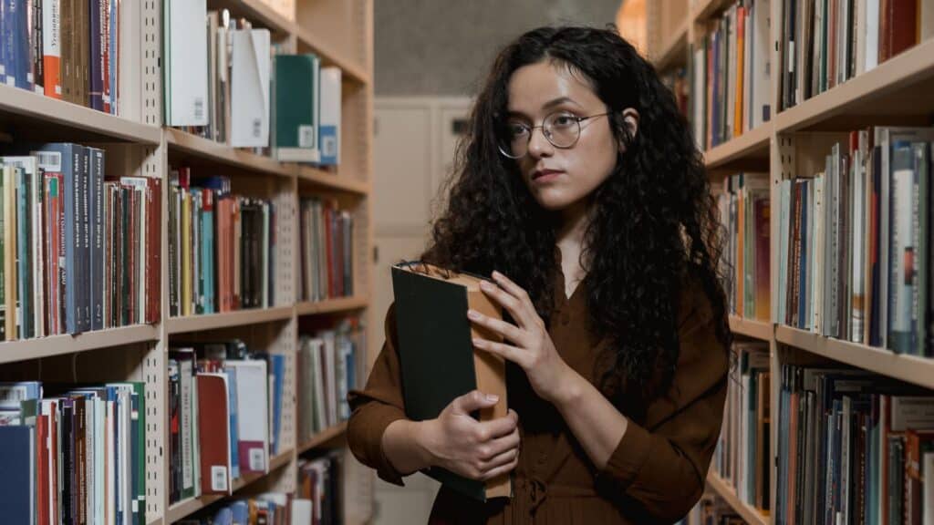 woman-in-library-holding-book-bans