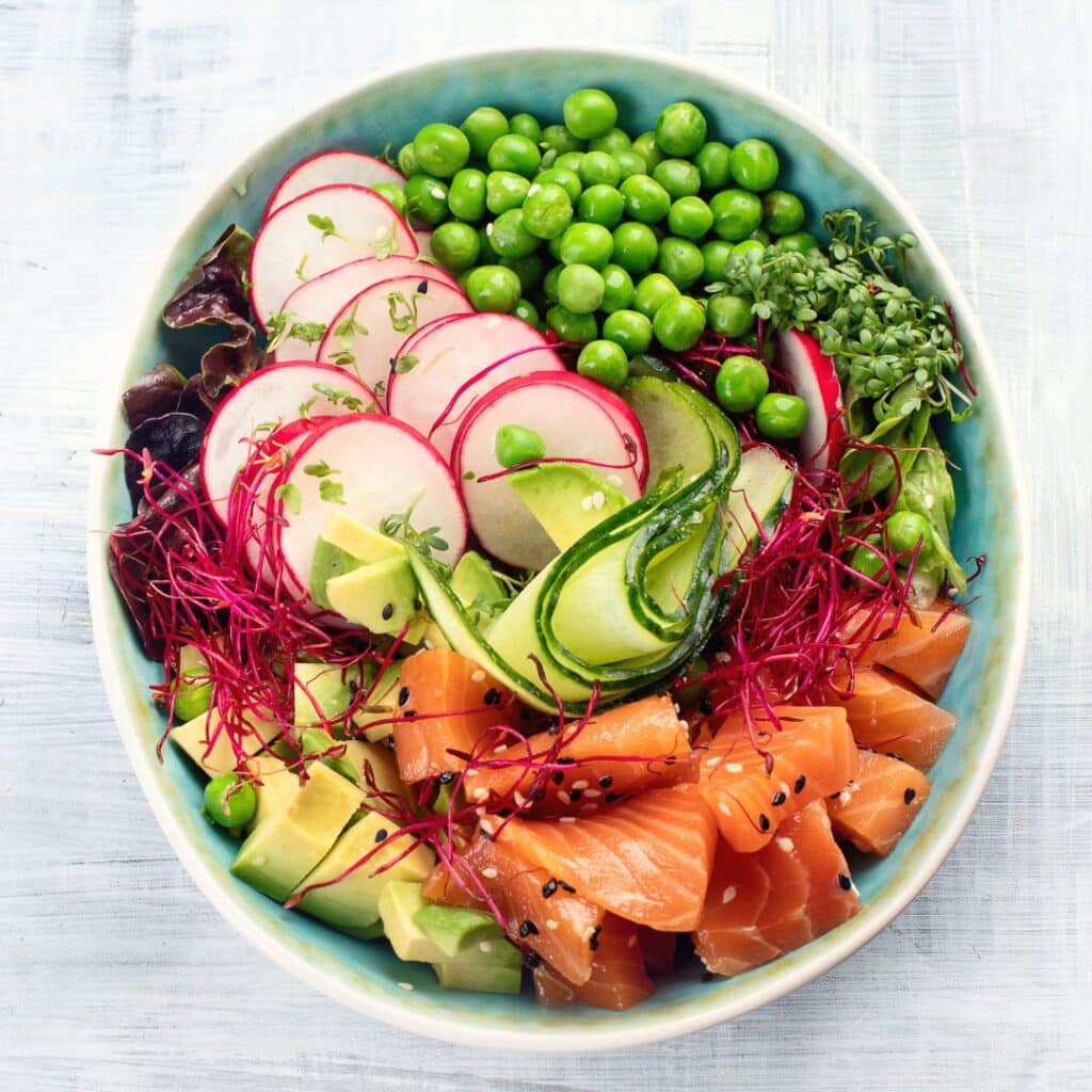 A poke bowl with salmon, radish, avocado, peas and cucumber.-food-truck-genre-reading