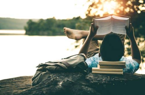 image-of-a-boy-reading-a-book-on-the-banks-of-a-waterbody-words-hugs-embrace-reading