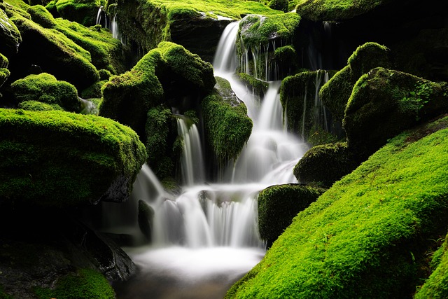 green-rocks-and-cliffs-surrounding-multiple-levels-of-waterfalls