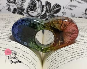 10-tempting-gifts-queer-book-nerds-will-love-rainbow-heart-page-holder-keeping-open-a-book