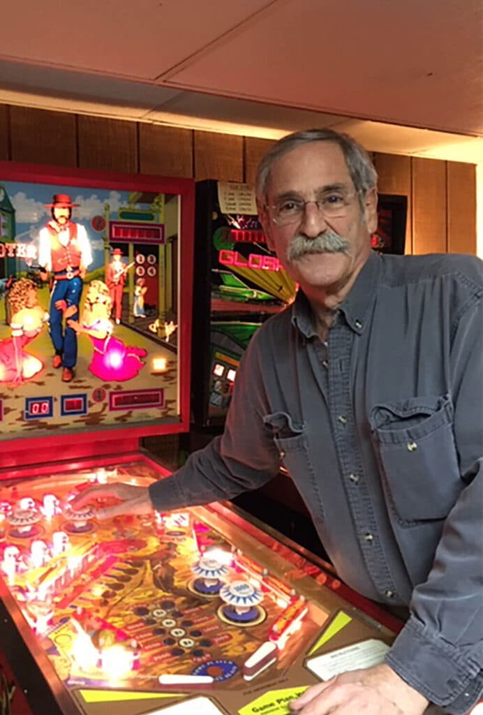 roger-sharpe-author-image-standing-in-front-of-pinball-machine-after-successfully-overturning-new york city-ban