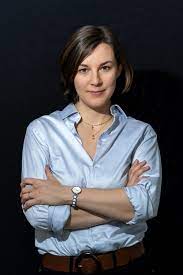 Anne-Sophie Brasme looking at the camera with dark blue background