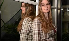 Christelle Dabos standing in front of a window with her reflection behind her