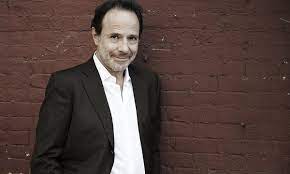 Marc Levy smiling with a brick background