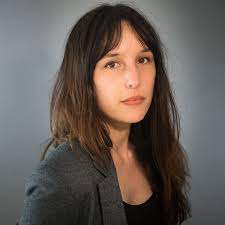 Victoria Mas staring at the camera with a gray background