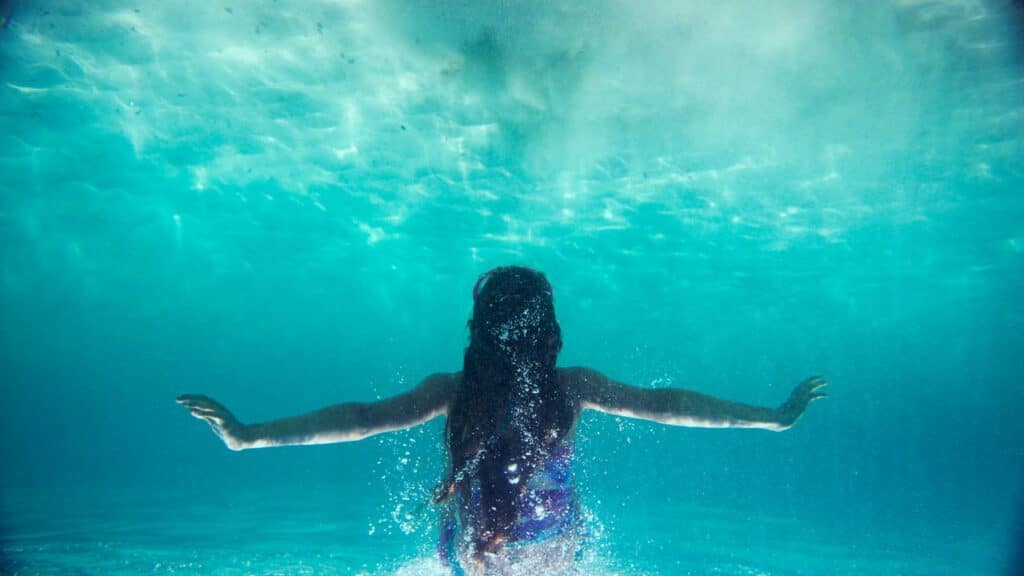 sensational-ocean-themes-to-write-about-this-national-clean-beaches-week-girl-underwater-with-arms-outstretched